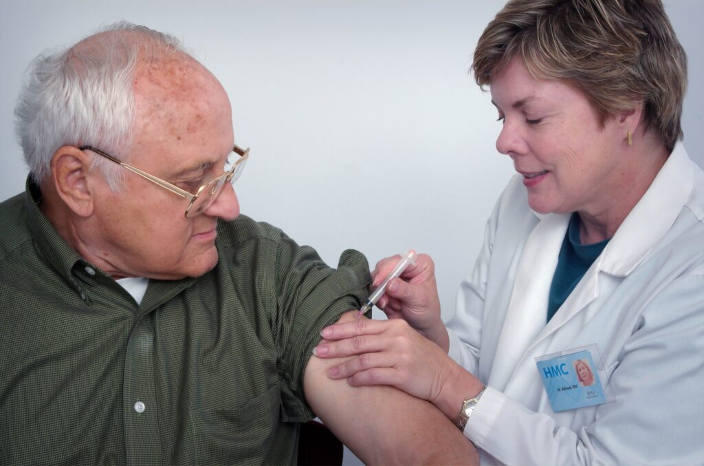 Old man receiving vaccination shot